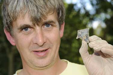 Jim Rylatt, a Post Graduate student from the University of Manchester with a Neolithic chisel arrowhead/Aerial-Cam